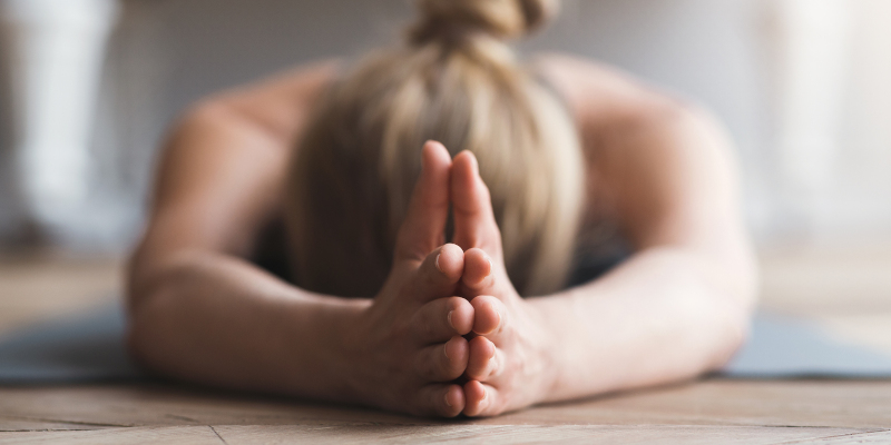 Woman laying face down on yoga mat, meditating Test Therapist